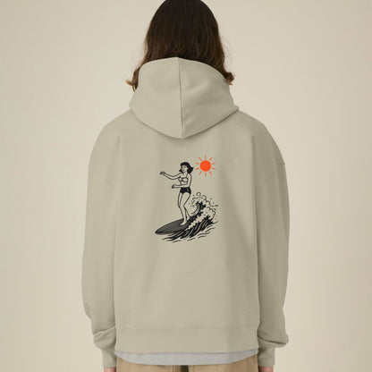 Person wearing a light gray hoodie with a graphic design on the back against a beige background