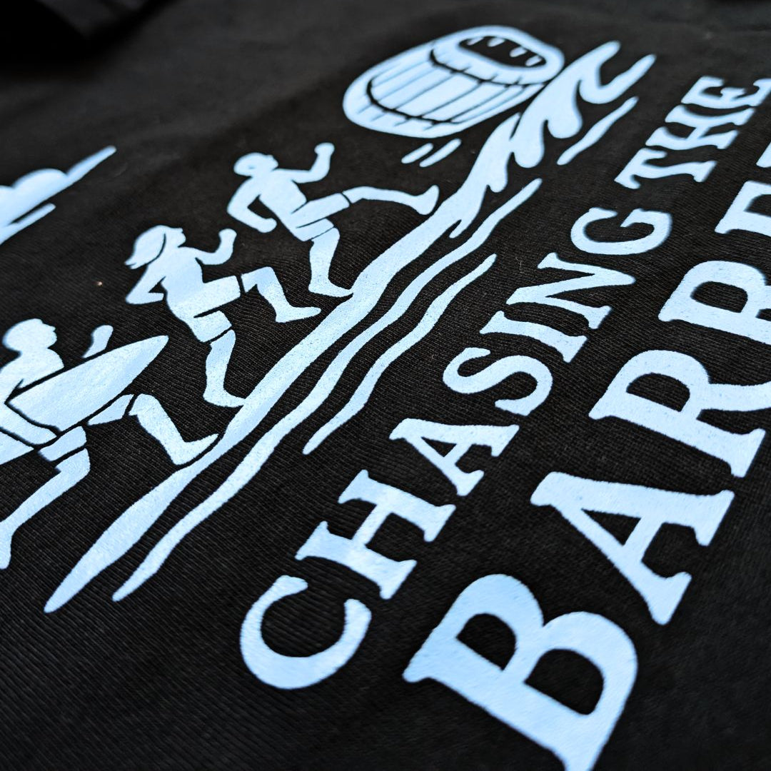 Black t-shirt with light blue graphic design and text 'Chasing the Bar' on a plain background