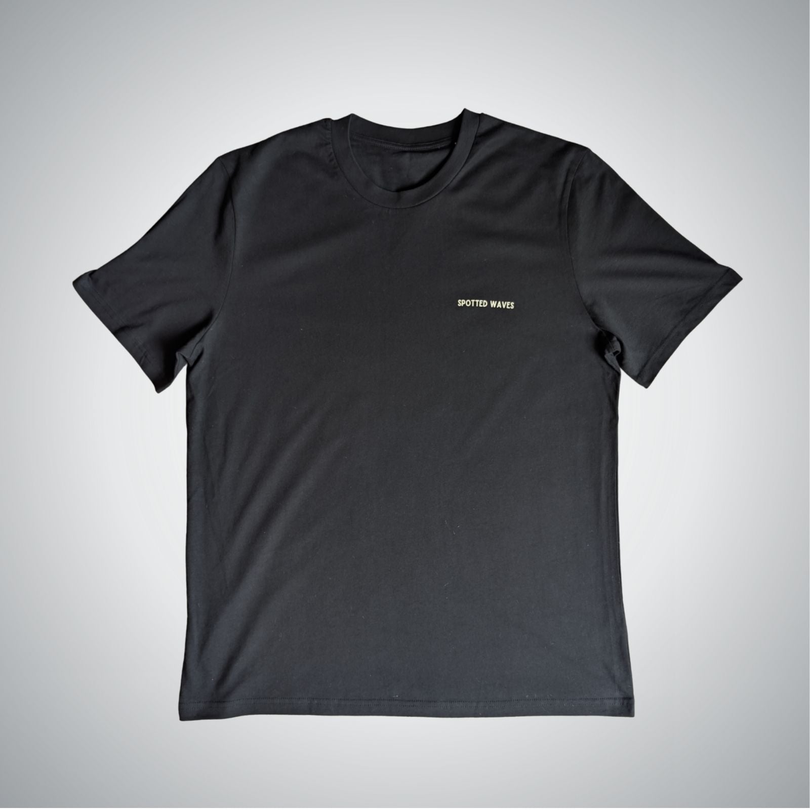 Black t-shirt with a small logo on a light gray background