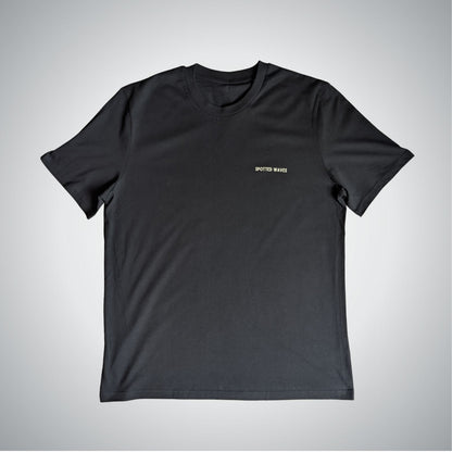 Black t-shirt with a small logo on a light gray background