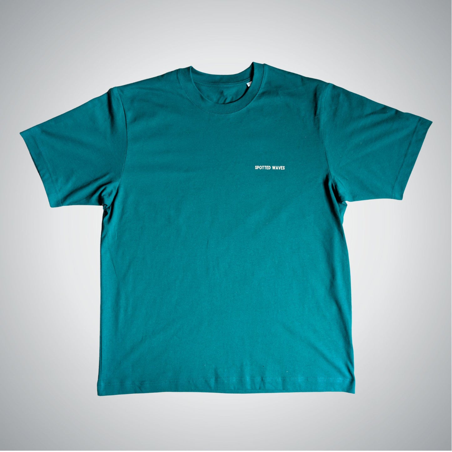 Teal t-shirt with a small white logo on a light gray background