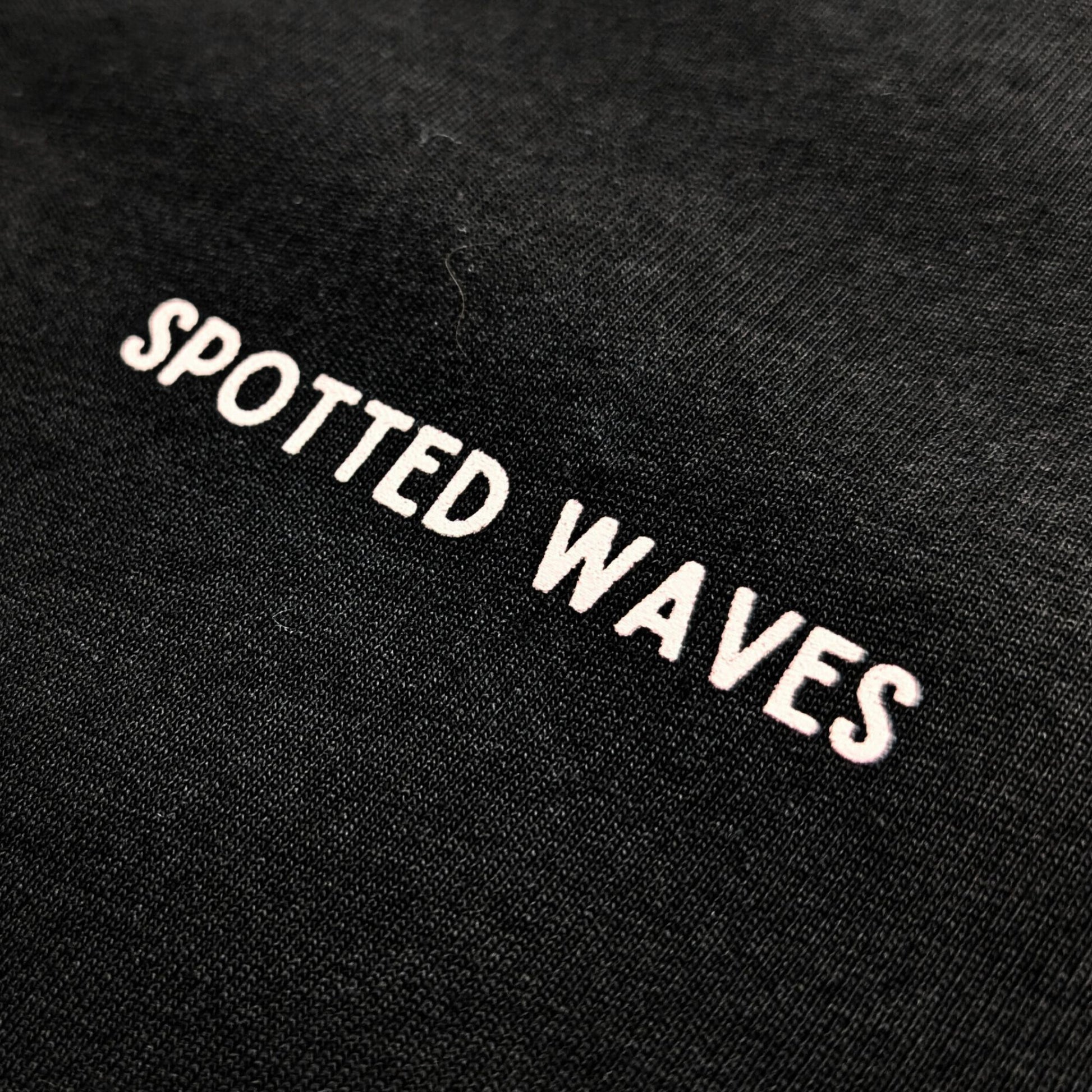 Black fabric with 'Spotted Waves' embroidered in white