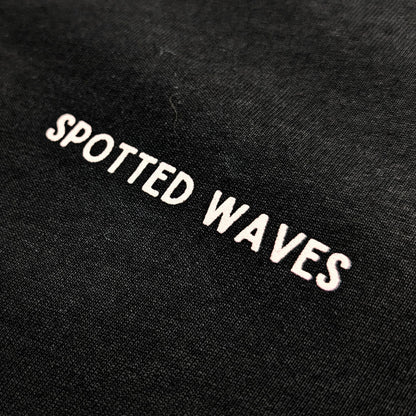 Black fabric with 'Spotted Waves' embroidered in white