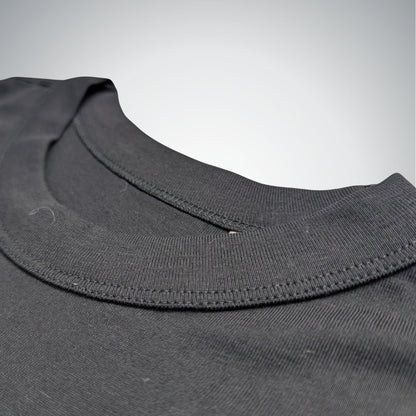 Close-up of a black shirt collar with stitching details on a light gray background