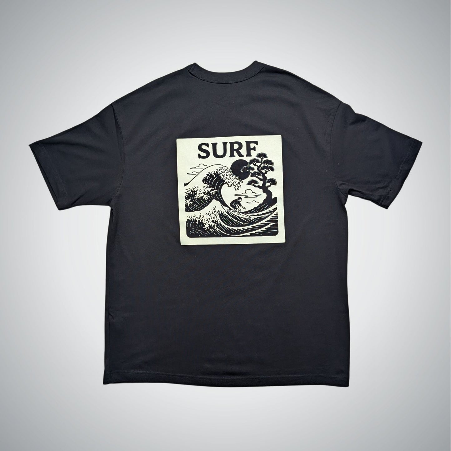 Black t-shirt with 'SURF' and wave design on a gray background