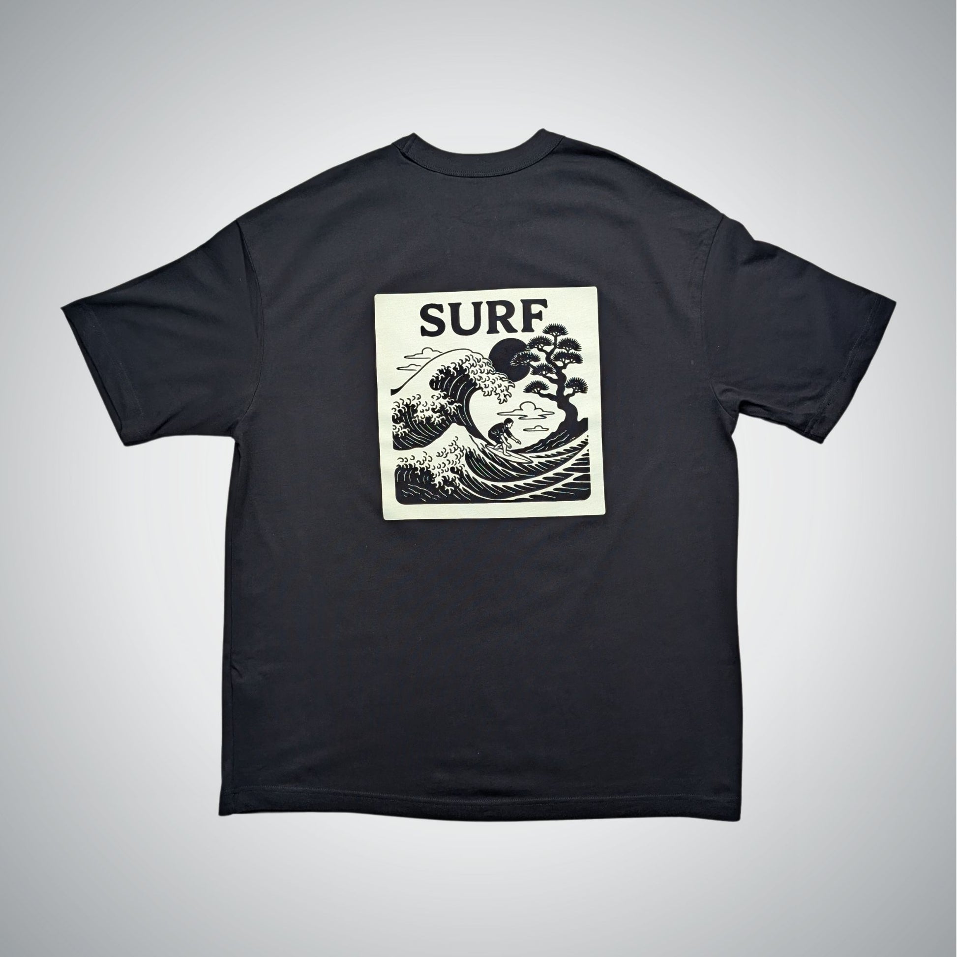 Black t-shirt with 'SURF' and wave design on a gray background